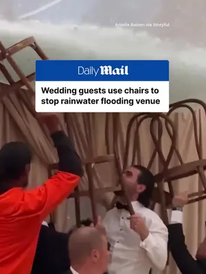 Wedding guests use chairs to stop rainwater flooding venue